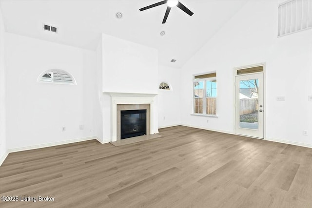 unfurnished living room featuring hardwood / wood-style floors, high vaulted ceiling, and ceiling fan