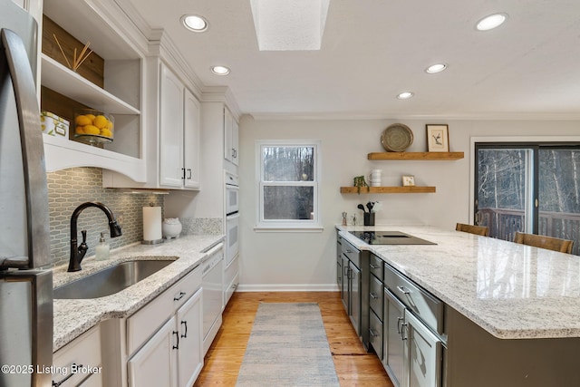 kitchen with a sink, white appliances, white cabinetry, and open shelves