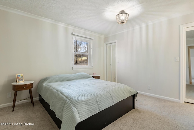 bedroom with baseboards, a closet, a textured ceiling, crown molding, and light colored carpet