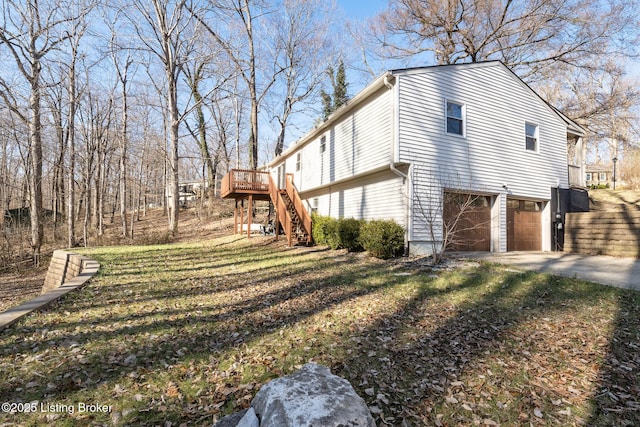 view of side of property with stairs, a deck, an attached garage, and driveway