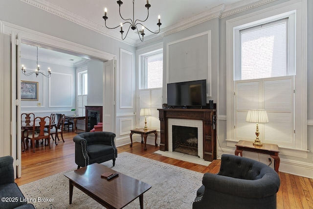 living room with crown molding, light hardwood / wood-style flooring, and a chandelier