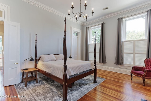 bedroom with hardwood / wood-style floors, a chandelier, and ornamental molding