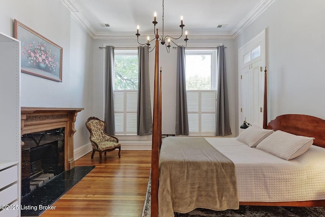 bedroom with hardwood / wood-style floors, a notable chandelier, and crown molding