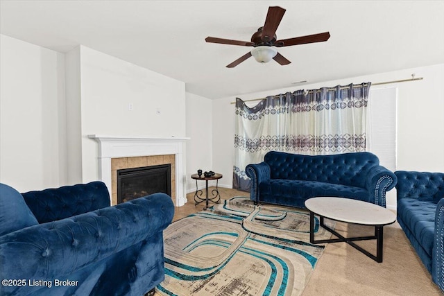 carpeted living room with ceiling fan and a fireplace