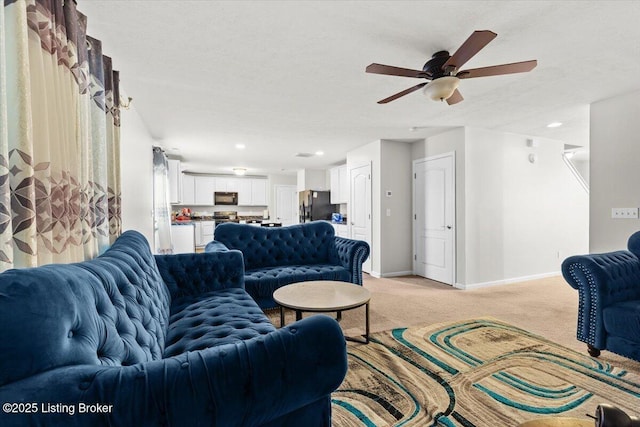 living room with ceiling fan, light colored carpet, and a textured ceiling