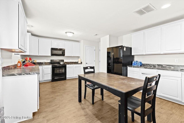 kitchen with white cabinets, black appliances, and light wood-type flooring