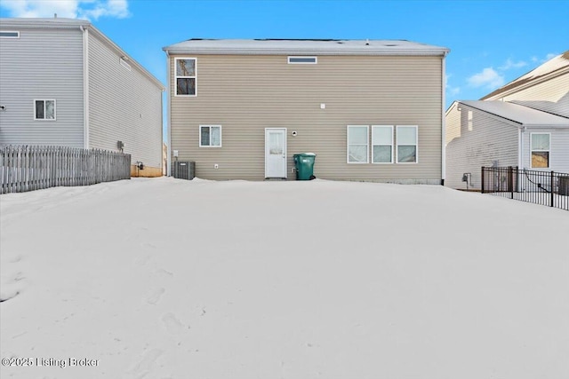 snow covered back of property featuring central AC