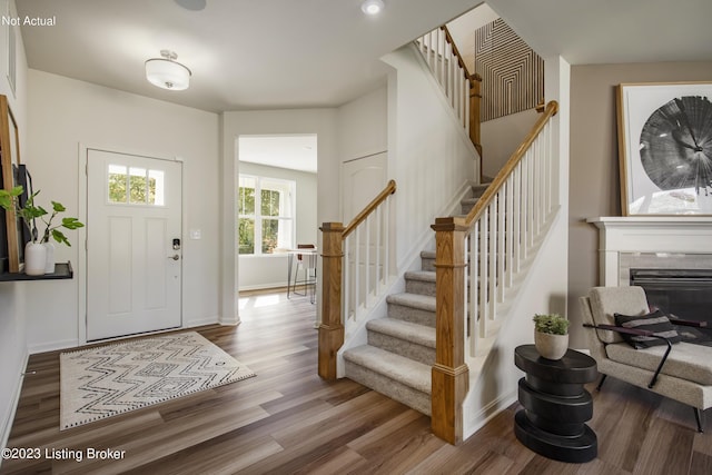 foyer entrance with hardwood / wood-style flooring and a tiled fireplace