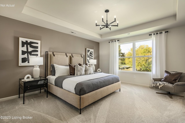 bedroom with a chandelier, carpet floors, and a tray ceiling