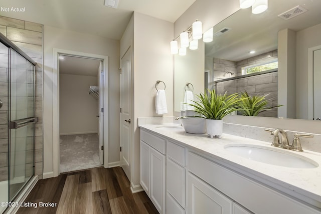 bathroom with hardwood / wood-style flooring, vanity, and an enclosed shower