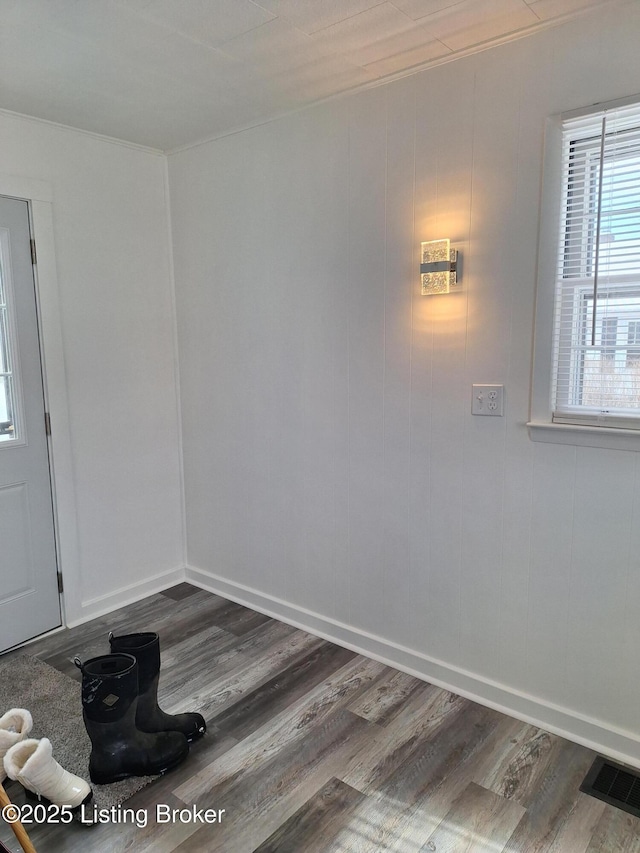 interior space with dark wood-style flooring, visible vents, and baseboards