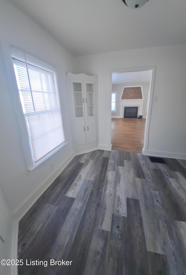 unfurnished dining area featuring a wealth of natural light and dark hardwood / wood-style flooring