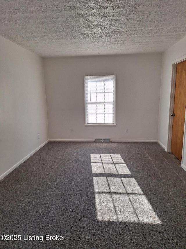 carpeted empty room featuring a textured ceiling, visible vents, and baseboards