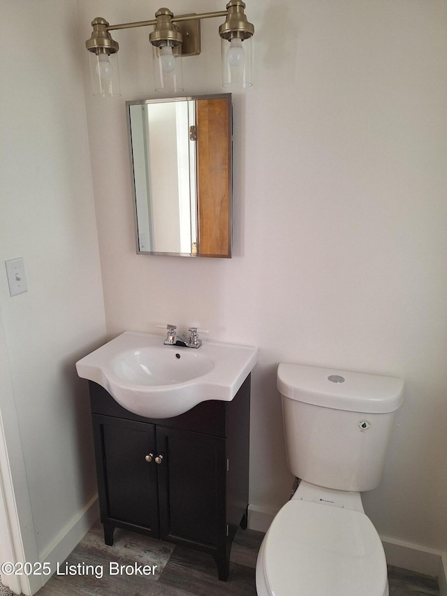 bathroom featuring baseboards, vanity, and toilet