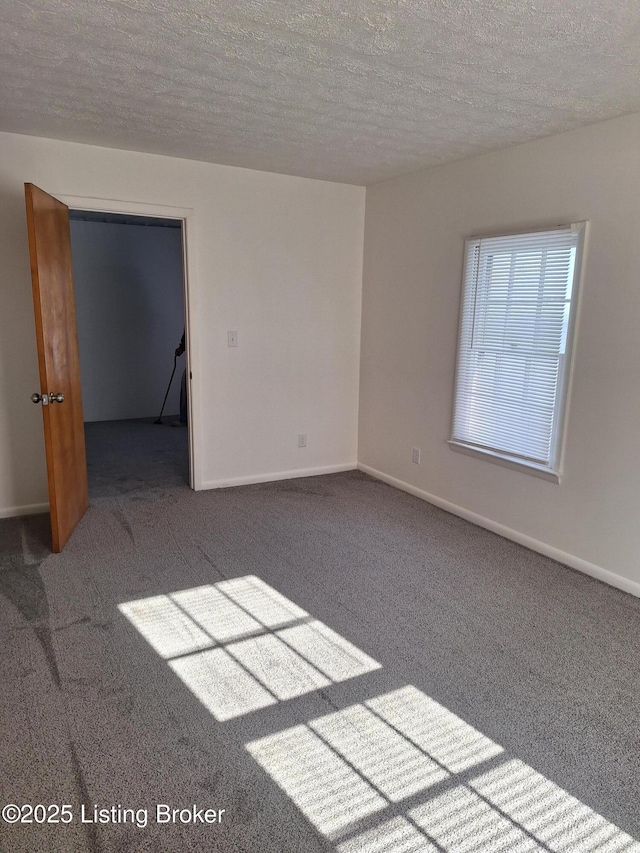 carpeted spare room with a textured ceiling