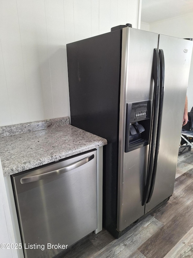 kitchen with appliances with stainless steel finishes, light stone countertops, white cabinets, and dark wood-style floors