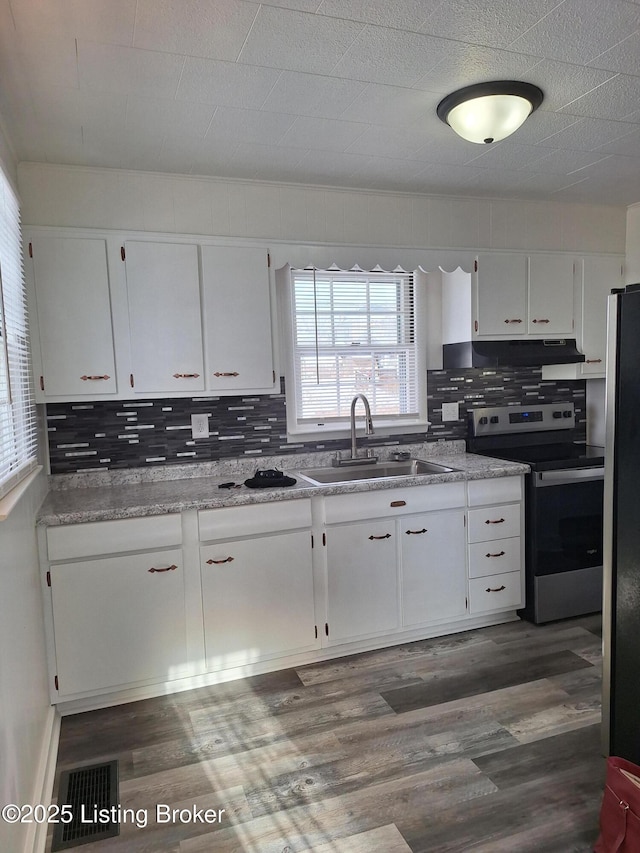 kitchen featuring visible vents, freestanding refrigerator, white cabinets, a sink, and stainless steel electric range