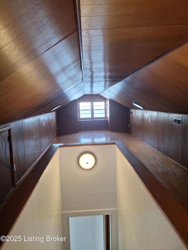 additional living space featuring wooden walls, wooden ceiling, and vaulted ceiling