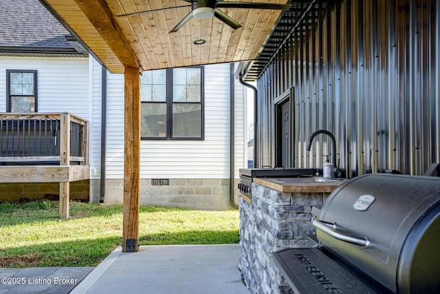 view of patio with grilling area, ceiling fan, and a wet bar