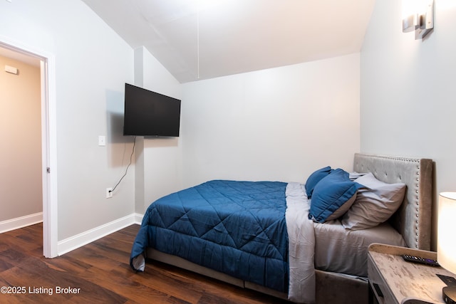 bedroom with dark wood-type flooring and lofted ceiling