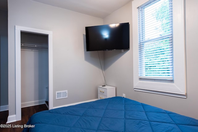 bedroom with lofted ceiling, dark wood-type flooring, and a closet