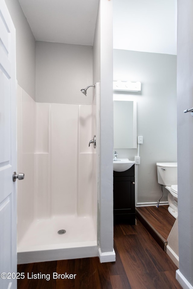 bathroom with vanity, hardwood / wood-style flooring, toilet, and walk in shower