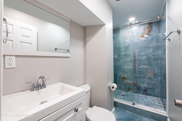 bathroom featuring vanity, toilet, and a shower with door