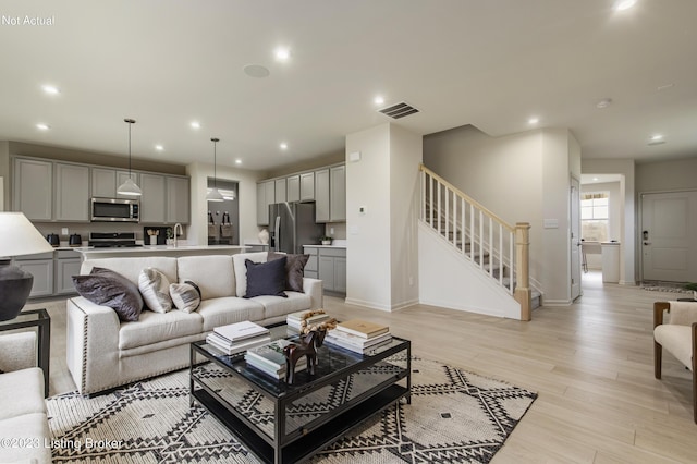 living room featuring light hardwood / wood-style flooring and sink