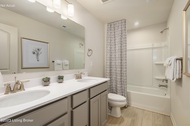 full bathroom with hardwood / wood-style floors, vanity, toilet, and shower / bath combo with shower curtain