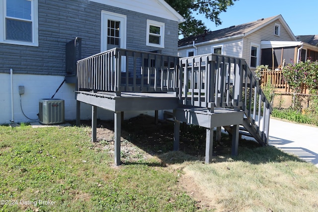 rear view of house featuring a deck, a lawn, and central air condition unit