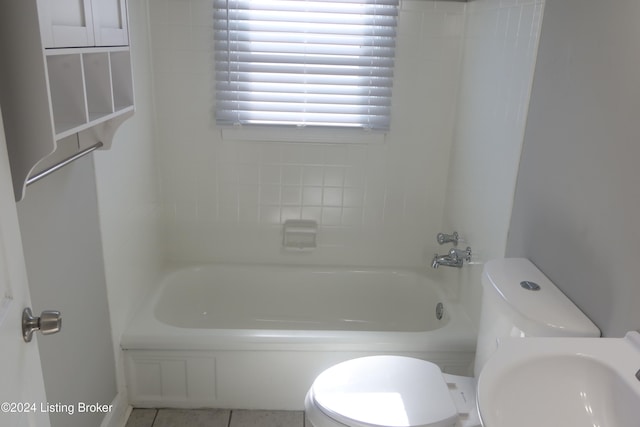 full bathroom featuring tile patterned flooring, tiled shower / bath combo, toilet, and sink