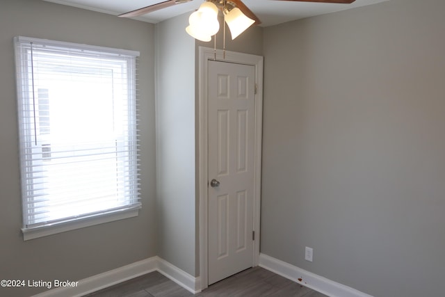 unfurnished bedroom with multiple windows, ceiling fan, and dark wood-type flooring