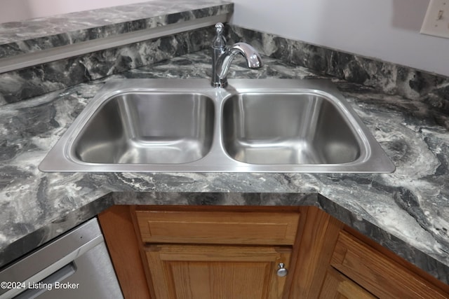 room details with dishwasher, dark stone countertops, and sink