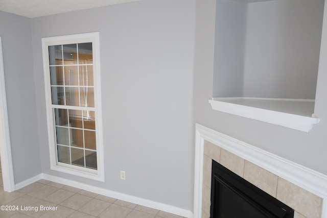 interior details featuring a tiled fireplace