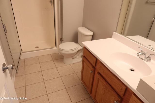 bathroom with toilet, tile patterned flooring, vanity, and walk in shower