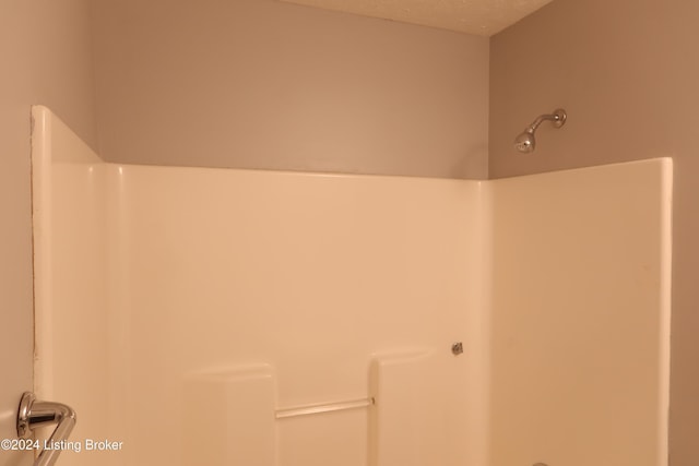 bathroom with a textured ceiling and walk in shower