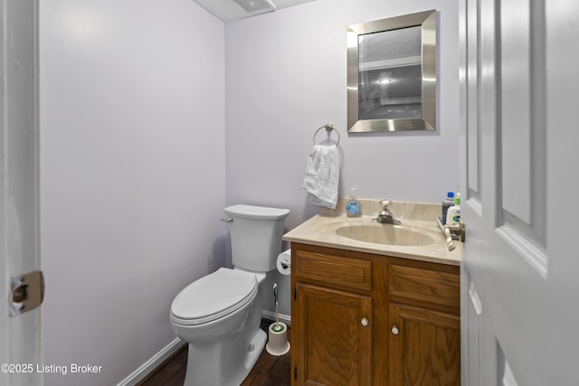 bathroom with hardwood / wood-style flooring, vanity, and toilet