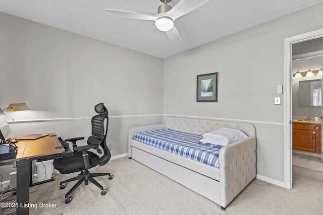 bedroom with ceiling fan, sink, ensuite bathroom, and light carpet