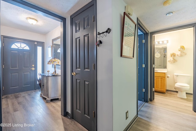 entryway with light hardwood / wood-style floors and a textured ceiling