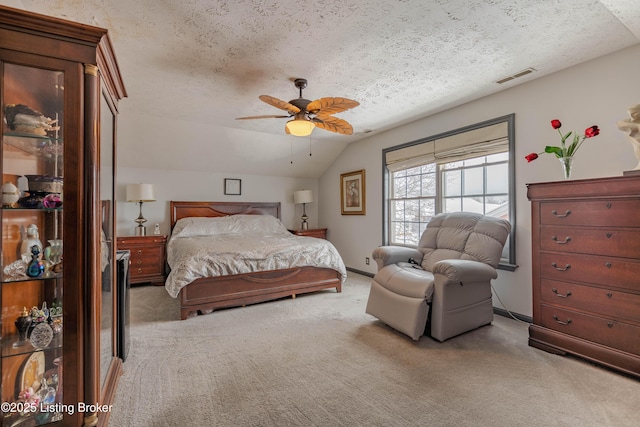 carpeted bedroom featuring ceiling fan, a textured ceiling, and vaulted ceiling