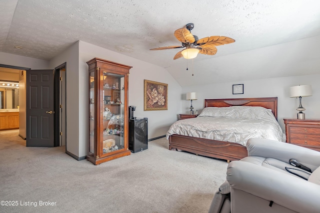 bedroom with vaulted ceiling, ensuite bath, ceiling fan, a textured ceiling, and light colored carpet