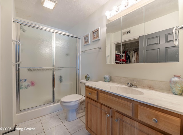 bathroom with tile patterned floors, a textured ceiling, an enclosed shower, toilet, and vanity