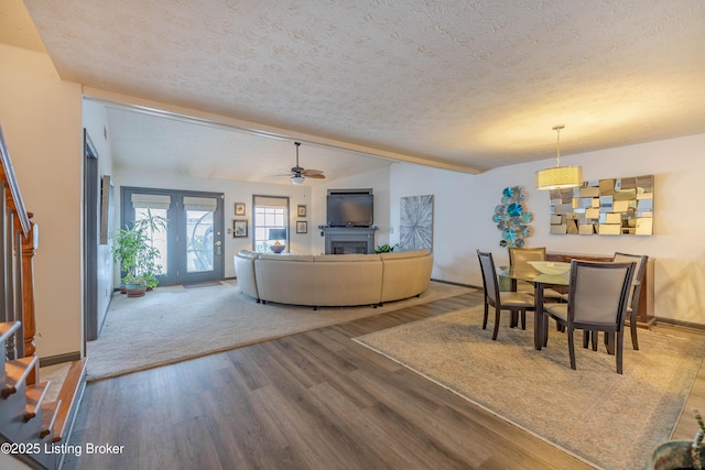 living room featuring a textured ceiling, hardwood / wood-style flooring, vaulted ceiling, and ceiling fan