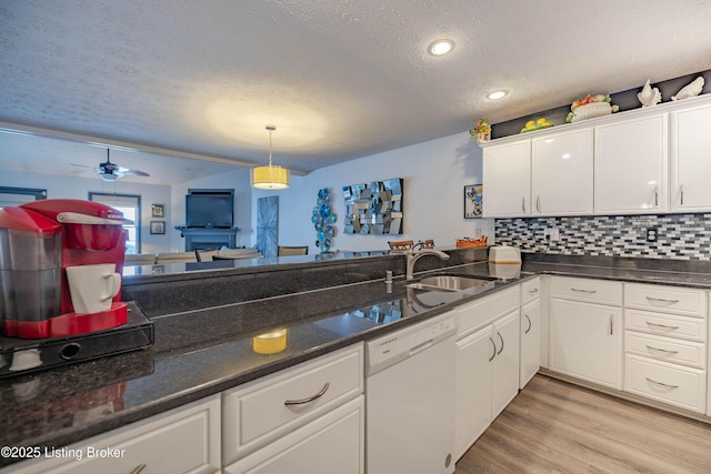 kitchen with a textured ceiling, white dishwasher, ceiling fan, sink, and white cabinetry