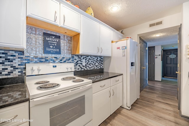 kitchen with white appliances, backsplash, white cabinets, a textured ceiling, and light hardwood / wood-style floors