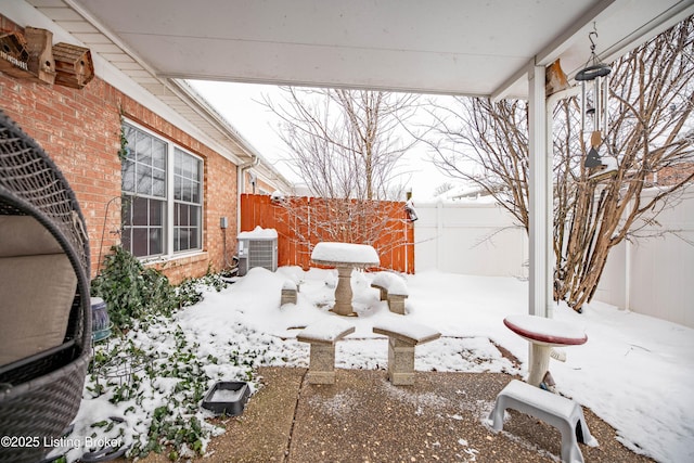 snow covered patio featuring central air condition unit