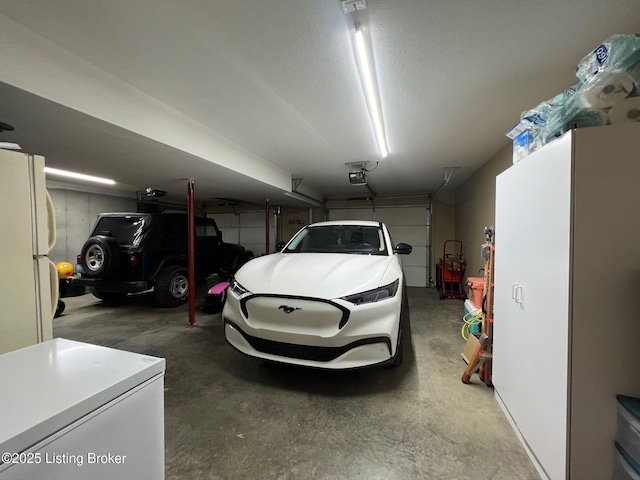 garage with white refrigerator, a garage door opener, and refrigerator