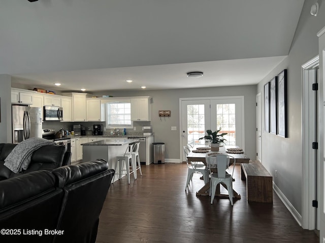 dining space with sink, dark wood-type flooring, and a healthy amount of sunlight