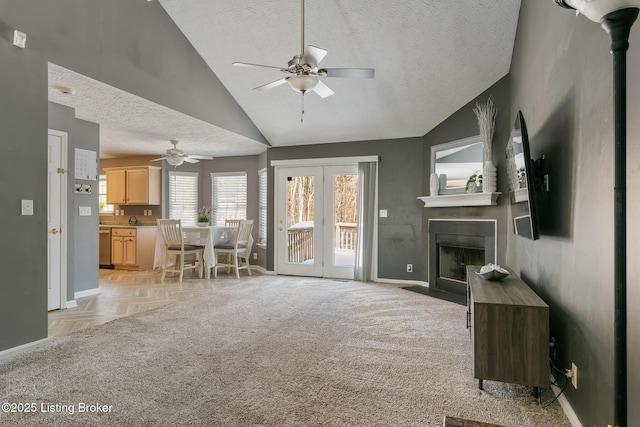 living room featuring vaulted ceiling, ceiling fan, light carpet, and a textured ceiling