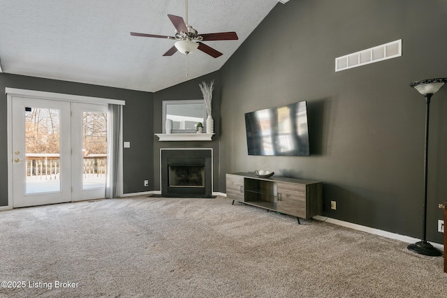 unfurnished living room with a textured ceiling, light colored carpet, ceiling fan, and lofted ceiling